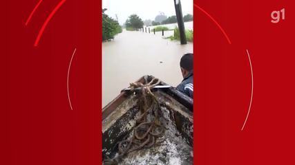 Mulher é levada de barco por local onde era uma rua em Cachoeiras de Macacu após chuva