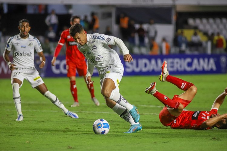 Marcos Leonardo com a bola dominada olha para baixo enquanto adversário está caído