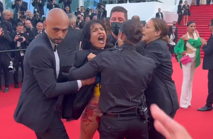 Seguranças do Festival de Cannes retirando manifestante do tapete vermelho
