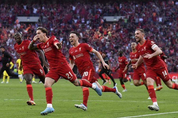 Tsimikas, do Liverpool, coloca a mão direita no ouvido e, seguido pelos companheiros, corre comemorando o título da Copa da Inglaterra