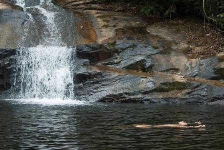 Homem toma banho de cachoeira no Parque Estadual do Mendanha