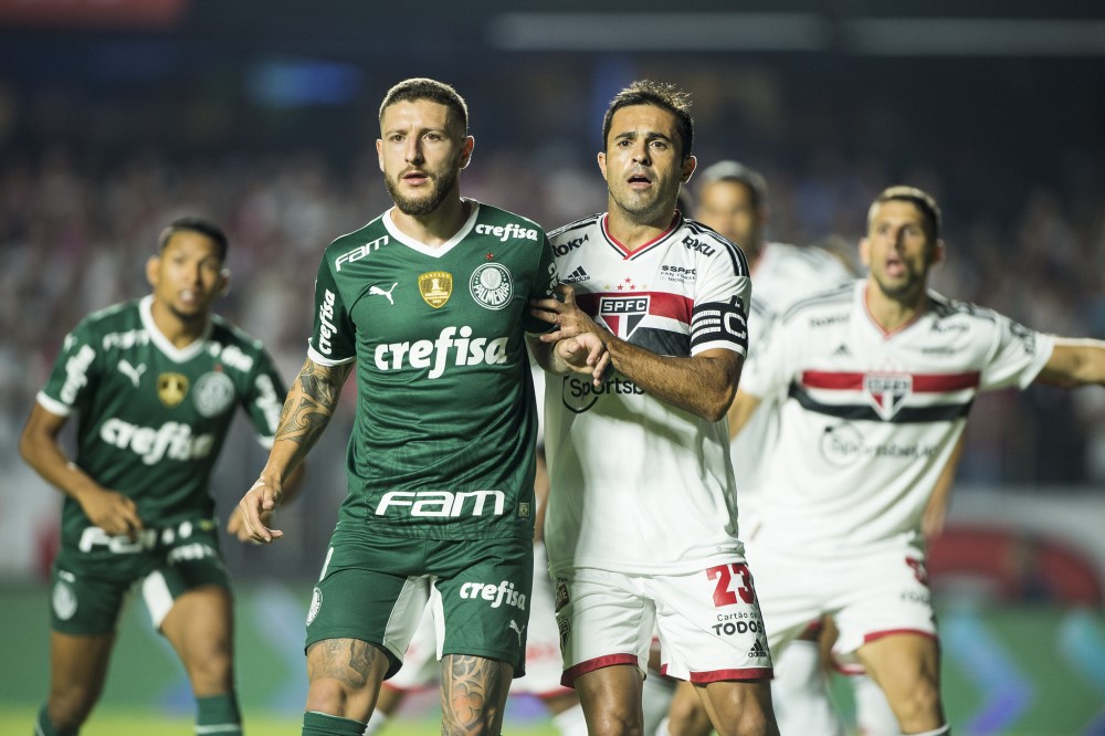 Zé Rafael e Eder, um segurando o outro em um lance de bola parada, com outros atletas de Palmeiras e São Paulo atrás