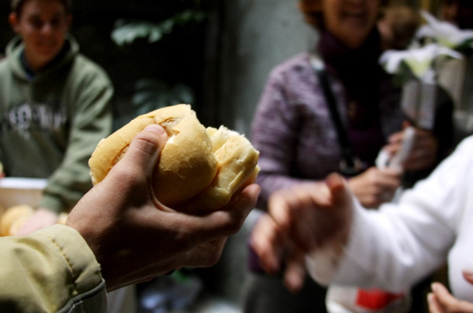 pessoa distribuindo um pedaço de pão