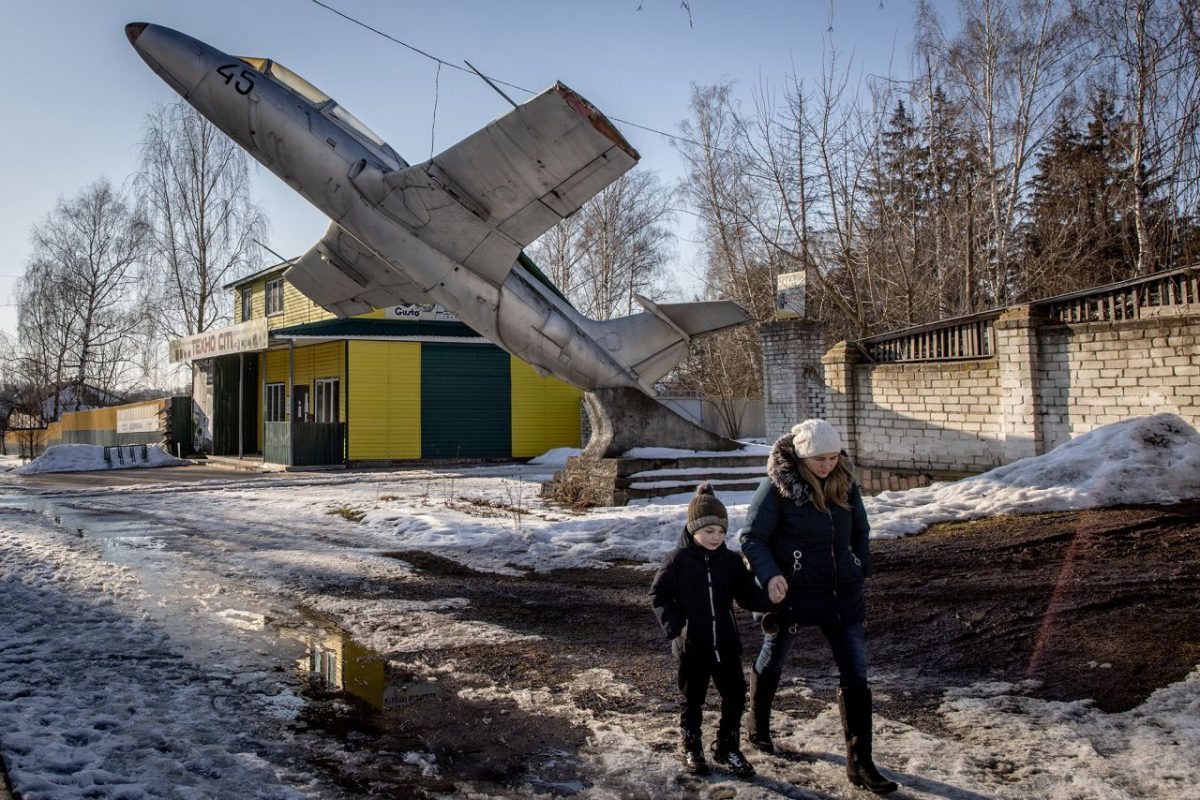A woman and child walk underneath a military monument in Senkivka, Ukraine, on February 14. It