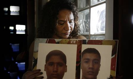 Elizabeth Paulino segura foto dos dois filhos assassinados