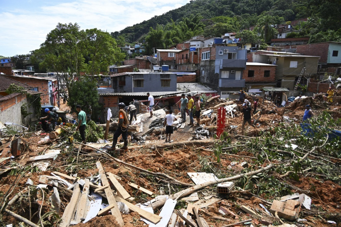 Pessoas removem detritos em uma área afetada por enchentes em Barra do Sahy, distrito de São Sebastião, no litoral norte de São Paulo