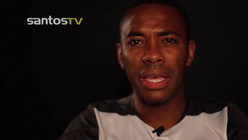 Robinho de costas em jogo do Santos, usando uniforme listrado do clube
