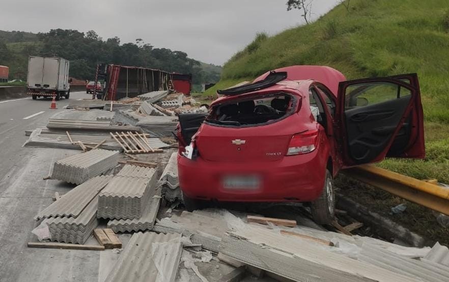 Carreta que transportava telhas tomba e parte da carga atinge carro em Piraí