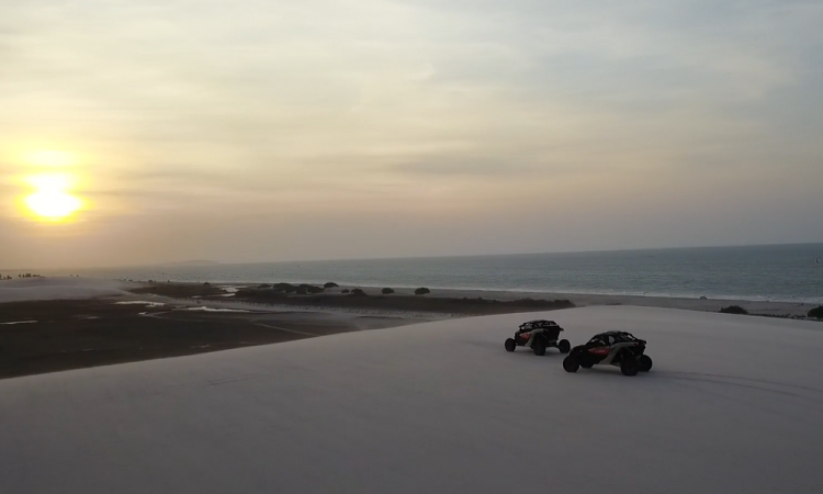 Dois carros off-road em praia de duna