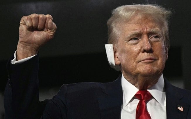 O ex-presidente dos EUA e candidato presidencial republicano de 2024, Donald Trump, com um curativo na orelha após ser ferido em uma tentativa de assassinato, levanta o punho ao chegar à Convenção Nacional Republicana de 2024 no Fórum Fiserv em Milwaukee, Wisconsin, 15 de julho de 2024 O ex-presidente dos EUA e candidato presidencial republicano de 2024, Donald Trump, com um curativo na orelha após ser ferido em uma tentativa de assassinato, levanta o punho ao chegar à Convenção Nacional Republicana de 2024 no Fórum Fiserv em Milwaukee, Wisconsin, 15 de julho de 2024