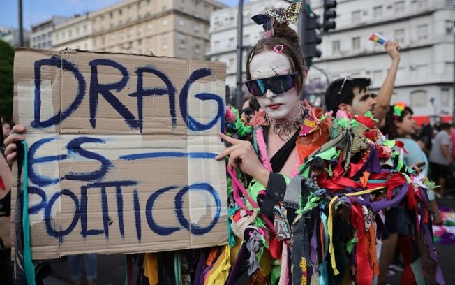 Um participante segura um cartaz que diz Um participante segura um cartaz que diz
