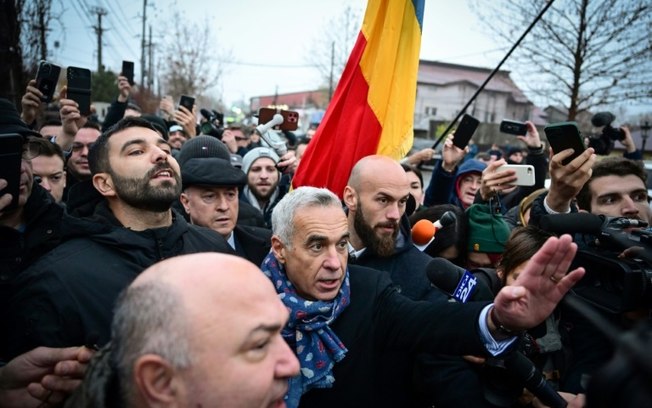 O candidato de extrema direita romeno, Calin Georgescu, durante uma manifestação contra a anulação da eleição presidencial, em frente a uma seção eleitoral em Mogosoaia, perto de Bucareste, em 8 de dezembro de 2024 O candidato de extrema direita romeno, Calin Georgescu, durante uma manifestação contra a anulação da eleição presidencial, em frente a uma seção eleitoral em Mogosoaia, perto de Bucareste, em 8 de dezembro de 2024