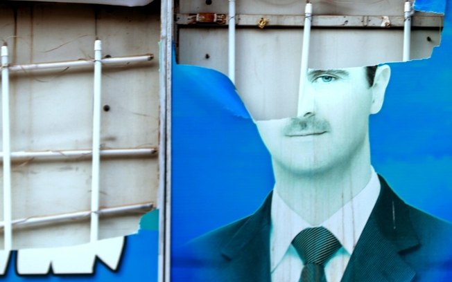 Uma foto danificada do presidente sírio deposto, Bashar al-Assad, exposta na cidade de Qamishli, em 8 de dezembro de 2024