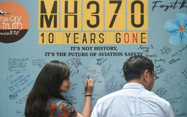 Mulher escreve mensagem durante evento do 10º aniversário do desaparecimento do voo MH370 da Malaysia Airlines