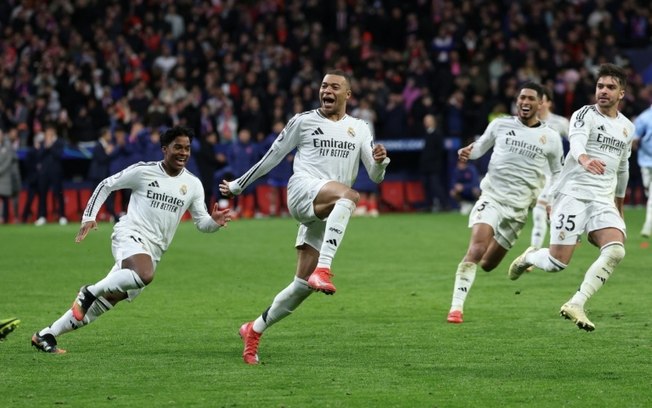 O atacante francês do Real Madrid, Kylian Mbappé (c), comemora com seus companheiros após vencer a disputa de pênaltis no jogo de volta das oitavas de final da Liga dos Campeões contra o Atlético de Madrid, no Metropolitano, em 12 de março de 2025