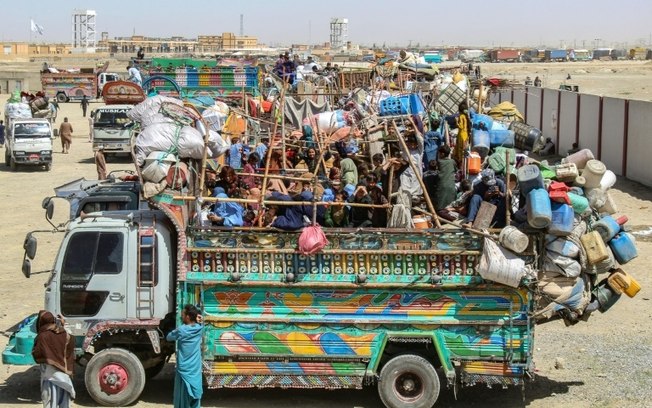 Um caminhão cheio de refugiados afegãos e carregado com seus pertences espera para partir para o Afeganistão em um centro de recepção perto da fronteira entre o Paquistão e o Afeganistão em Chaman, em 11 de abril de 2025