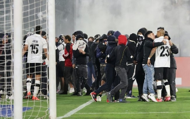 Torcedores invadem o campo durante a partida da fase de grupos da Copa Libertadores entre o Colo Colo e o Fortaleza, no estádio Monumental David Arellano, em Santiago, em 10 de abril de 2025.