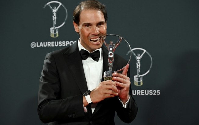 O ex-tenista espanhol Rafael Nadal morde o troféu durante a cerimônia do Prêmio Laureus em Madri, em 21 de abril de 2025.