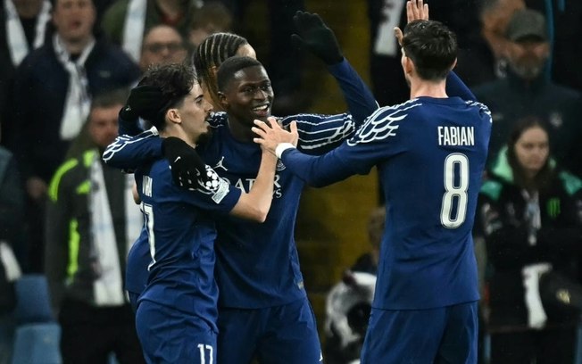 O zagueiro português do Paris Saint-Germain, Nuno Mendes (centro), comemora seu gol contra o Aston Villa na partida de volta das quartas de final da Liga dos Campeões, em 15 de abril de 2025, em Birmingham.