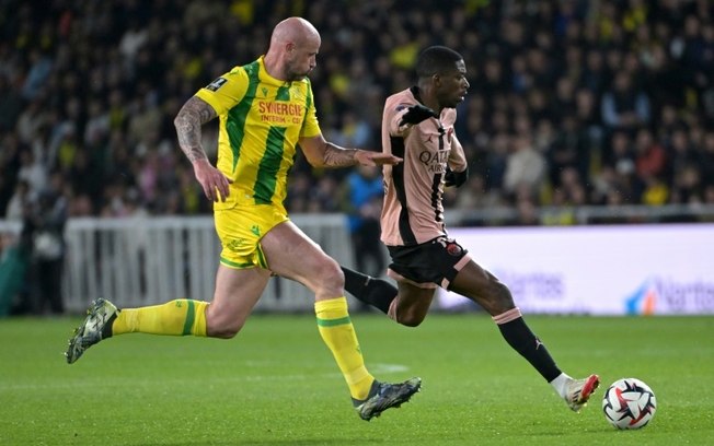 O atacante Ousmane Dembele (à direita) do Paris Saint-Germain e o zagueiro Nicolas Pallois (à esquerda) do Nantes disputam a bola durante a partida da Ligue 1 no Stade de la Beaujoire–Louis Fonteneau em Nantes, em 22 de abril de 2025.