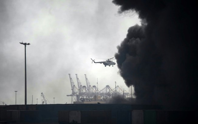 Helicóptero sobrevoa fumaça gerada pela explosão no porto de Shahid Rajaee, no sudoeste do Irã, em 26 de abril de 2025