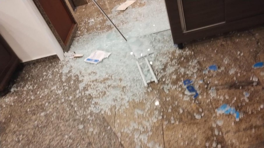 Vidro do refeitório do hotel atingido por disparos de arma de fogo.