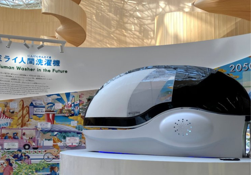 O Japão apresentou uma máquina lavar gente com roupa e tudo. Ela tem IA, não causa alergias na pele e ainda cuida da saúde metal. - Foto: Science Inc.