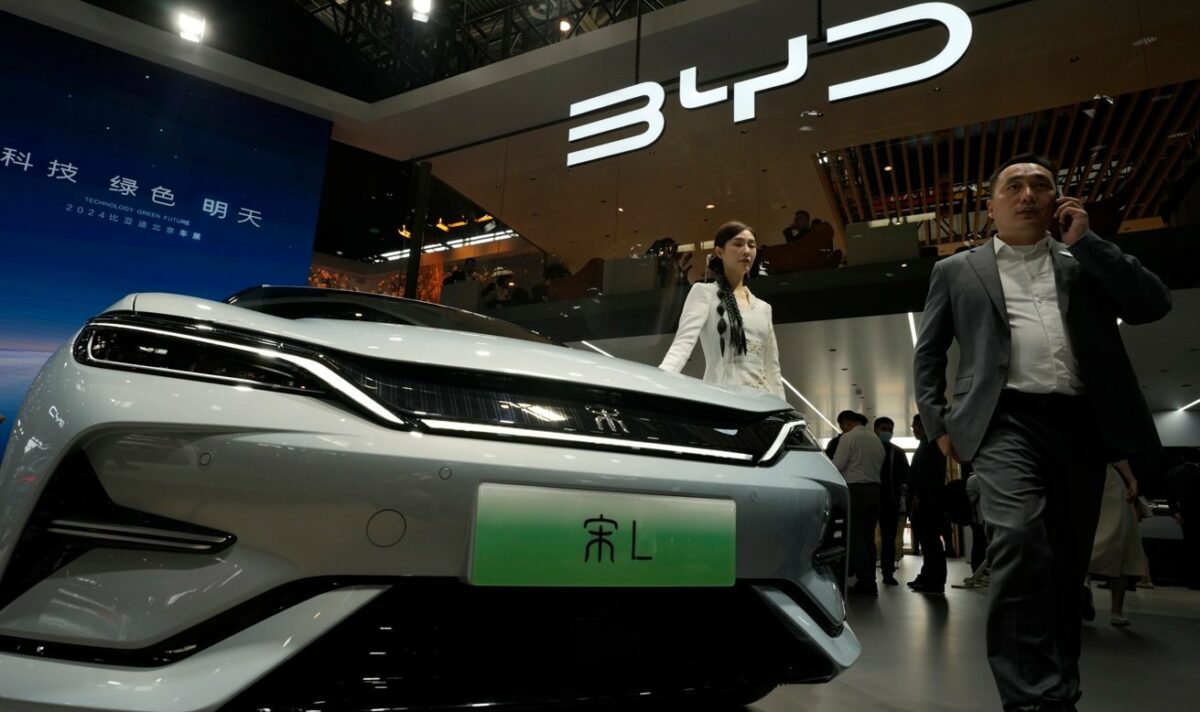 Uma modelo posa perto do carro elétrico BYD Song L durante a Auto China 2024, realizada em Pequim, em 25 de abril de 2024