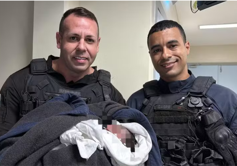 PMs resgatam bebê abandonado no lixo no Rio de Janeiro Os PMs retiraram o bebê ainda com o cordão umbilical do lixo, no Rio de Janeiro. - Foto: Divulgação