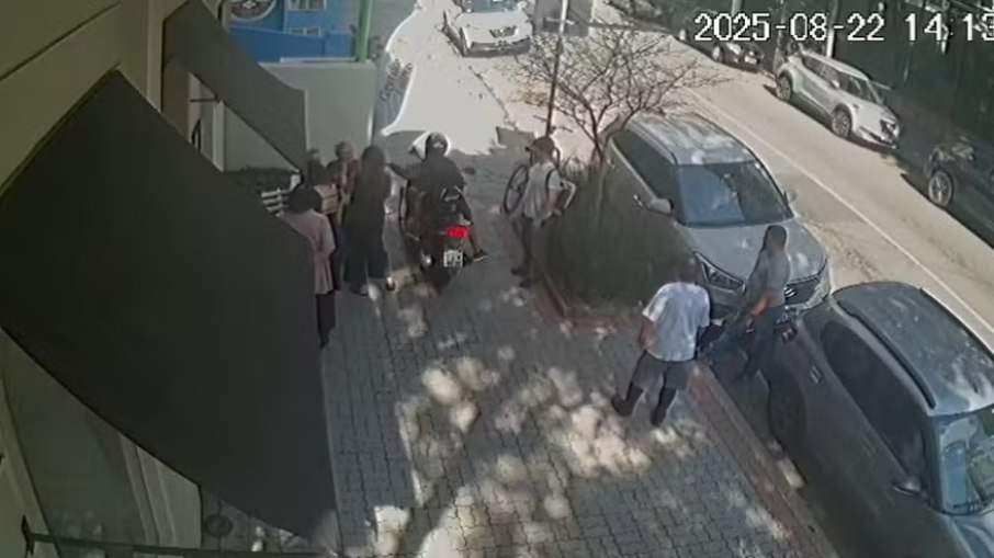 Momento em que a moto passa entre a equipe, na calçada, e leva o celular Momento em que a moto passa entre a equipe, na calçada, e leva o celular