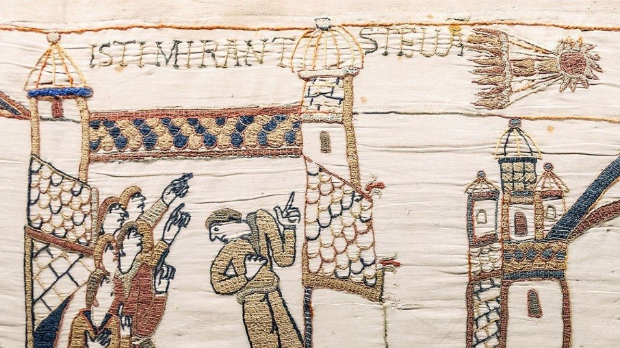 Um painel da tapeçaria de Bayeux mostrando pessoas olhando para o que mais tarde seria conhecido como cometa Halley.