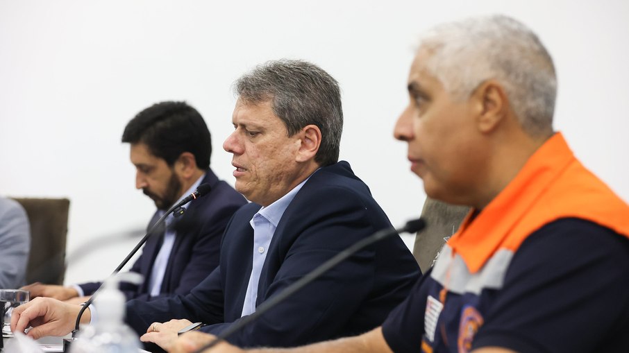 O governador Tarcísio de Freitas (Republicanos), entre o prefeito de São Paulo, Ricardo Nunes (MDB), e o  coordenador da Defesa Civil do Estado, Coronel Henguel Ricardo Pereira