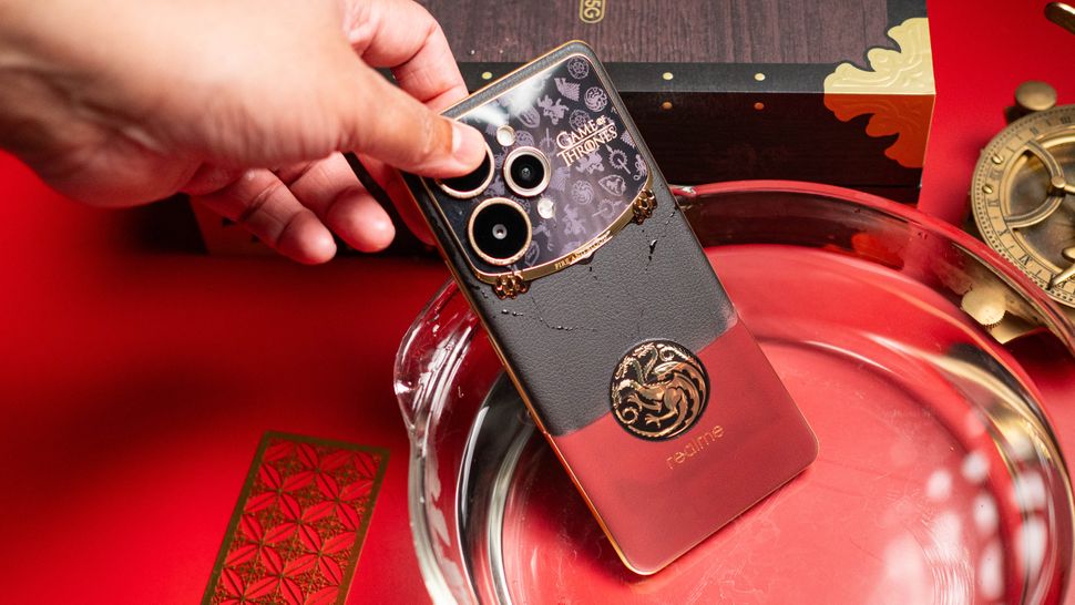 Foto do Realme 15 Pro Game of Thrones Edition sendo imerso em água quente, demonstrando a parte traseira mudando da cor preta para vermelho