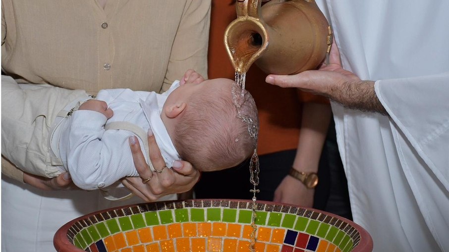 Batismo de bebê em SC captura imagem de cruz na água Batismo de bebê em SC captura imagem de cruz na água