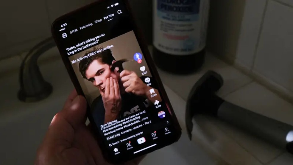 Imagem ilustrativa do movimento looksmaxxing, reproduzindo vídeo no TikTok de influenciador martelando a maçã de seu rosto para parecer mais masculino — Foto: Chris Delmas/AFP via Getty Images